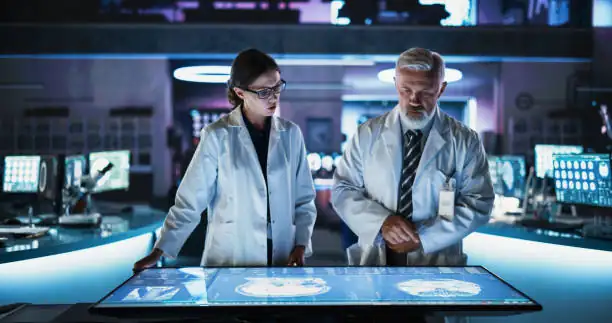 Research team reviewing data on an illuminated interactive display